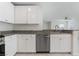 Bright kitchen featuring white cabinets, granite countertops, and a stainless steel dishwasher at 10943 Ketchikan St, Las Vegas, NV 89179