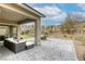 Covered backyard patio featuring plenty of lounge space, stone tiling, and well-kept landscaping at 11137 Black Fire Opal Dr, Las Vegas, NV 89138