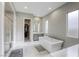 A modern bathroom features a standalone tub, shower, closet, vanity, and a tiled floor illuminated by recessed lighting at 11137 Black Fire Opal Dr, Las Vegas, NV 89138