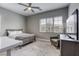 Bedroom includes a bed, desk, tv, ceiling fan and chair, illuminated by natural light through a large window at 11137 Black Fire Opal Dr, Las Vegas, NV 89138