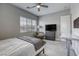 Bedroom includes a bed, desk, tv, ceiling fan and chair, illuminated by natural light through a large window at 11137 Black Fire Opal Dr, Las Vegas, NV 89138
