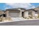 View of the home featuring attached garage, stone detailing and desert landscaping at 11137 Black Fire Opal Dr, Las Vegas, NV 89138