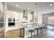 Modern kitchen features white cabinets, stainless steel appliances, granite countertops, and a breakfast bar with seating at 11137 Black Fire Opal Dr, Las Vegas, NV 89138