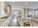 Gourmet kitchen with stainless steel appliances, granite countertops, white cabinets, and an open layout to the living area at 11137 Black Fire Opal Dr, Las Vegas, NV 89138