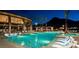 The community pool is surrounded by lounge chairs and palm trees, with a mountain backdrop, perfect for relaxation at 11137 Black Fire Opal Dr, Las Vegas, NV 89138