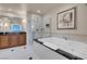 This bathroom features a soaking tub, glass enclosed shower, and wooden vanity with a marble countertop at 125 E Harmon Ave # 2220, Las Vegas, NV 89109
