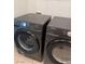 A close up of the modern, dark Samsung washer and dryer units in the laundry room at 1725 Queen Victoria St # 103, Las Vegas, NV 89144