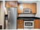 A modern kitchen with stainless steel refrigerator, oven, and wood cabinets at 200 W Sahara Ave # 1810, Las Vegas, NV 89102