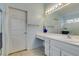 Bright bathroom with a white vanity, large mirror, and a doorway leading to a private toilet and shower area at 2105 High Mesa Dr, Henderson, NV 89012