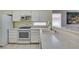 Charming kitchen featuring white cabinets and appliances, complemented by light countertops and tile flooring at 2105 High Mesa Dr, Henderson, NV 89012