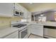 Well-lit kitchen boasts white cabinetry, appliances, and countertops, complemented by stainless steel dishwasher at 2105 High Mesa Dr, Henderson, NV 89012