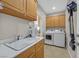 This laundry room features storage cabinets, a sink with countertop, and a washer and dryer at 2156 Shadow Canyon Dr, Henderson, NV 89044