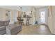 Open-concept living area with a kitchen bar, tile flooring, comfortable sofa, and access to the front door at 2156 Shadow Canyon Dr, Henderson, NV 89044