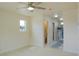 Spacious bedroom featuring a ceiling fan, light hardwood floors, and ensuite bathroom at 220 N David St, Pahrump, NV 89060