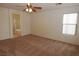 Spacious, carpeted bedroom featuring a ceiling fan, a window, and an ensuite bathroom at 2520 Living Rock St, Las Vegas, NV 89106