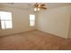 Bright, carpeted bedroom featuring natural light, a ceiling fan, and ample space for relaxation and personalization at 2520 Living Rock St, Las Vegas, NV 89106