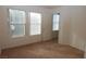 Well-lit carpeted bedroom with two large windows and a connecting doorway at 2520 Living Rock St, Las Vegas, NV 89106
