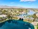 Lake community aerial view with waterfront homes, bridge, lush landscaping, and mountain backdrop at 2908 Reef Bay Ln, Las Vegas, NV 89128