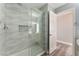 The remodeled bathroom offers a glass shower, decorative tile, and gray wood-look floors at 2908 Reef Bay Ln, Las Vegas, NV 89128