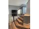 Modern staircase features wood steps and a sleek railing, leading to an open living space with a TV and cabinet at 2908 Reef Bay Ln, Las Vegas, NV 89128
