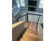 Looking down on a stylish staircase with wood steps and modern railing overlooking a living area with large windows at 2908 Reef Bay Ln, Las Vegas, NV 89128