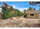 Serene backyard retreat featuring a cozy stone fire pit, mature trees, and a charming patio area at 3015 Duneville St, Las Vegas, NV 89146