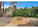 Charming backyard with a stone fire pit, lush greenery, and ample space for outdoor entertaining at 3015 Duneville St, Las Vegas, NV 89146