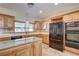 Updated kitchen featuring wood cabinets, granite countertops, and black appliances at 3015 Duneville St, Las Vegas, NV 89146