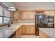 Traditional kitchen featuring wood cabinets, granite countertops, and a black refrigerator at 3015 Duneville St, Las Vegas, NV 89146