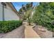 Charming side yard with a stone pathway, mature landscaping, and a serene atmosphere at 3015 Duneville St, Las Vegas, NV 89146