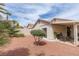 Relaxing backyard showcasing desert landscaping, including a covered patio and mature desert trees at 3239 Robins Creek Pl, Las Vegas, NV 89135