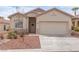 Front exterior of a single-story home featuring a two-car garage and xeriscaped front yard at 3239 Robins Creek Pl, Las Vegas, NV 89135