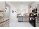 Open kitchen with stainless steel appliances, granite countertops, and white tile flooring at 3239 Robins Creek Pl, Las Vegas, NV 89135