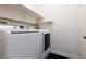 Modern laundry room featuring a front-load washer and dryer, and convenient shelving at 3239 Robins Creek Pl, Las Vegas, NV 89135