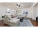 Bright living room features an oversized sectional, ceiling fan, and gorgeous hard wood floors at 3239 Robins Creek Pl, Las Vegas, NV 89135