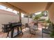 Inviting covered patio area featuring comfortable seating and a built-in grill, ideal for outdoor entertaining at 3239 Robins Creek Pl, Las Vegas, NV 89135