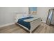 Comfortable bedroom with white frame bed, wood-look floors, and a bright window, perfect for relaxation at 3257 Coral Harbor Dr, Las Vegas, NV 89117