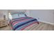 Cozy bedroom with wood-look floors and a striped blanket on the bed at 3257 Coral Harbor Dr, Las Vegas, NV 89117