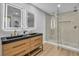 The primary bath features dual sinks, wood cabinets and a large glass enclosed shower with dual shower heads at 3334 W Mardon Ave, Las Vegas, NV 89139