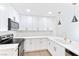 Bright kitchen features white cabinets, stainless steel appliances, subway tile backsplash, and gold pendant lights at 3339 Duece St, Las Vegas, NV 89121