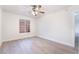 Bright bedroom featuring light wood-look flooring, a ceiling fan and natural light from the large window at 3517 S Dapple Gray Rd, Las Vegas, NV 89147