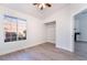 Bright bedroom with light wood-look floors, a ceiling fan, and a view through the window at 3517 S Dapple Gray Rd, Las Vegas, NV 89147