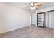 A bright bedroom featuring light wood-look flooring, ceiling fan, closet and door that leads to another room at 3517 S Dapple Gray Rd, Las Vegas, NV 89147