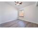 Bright bedroom featuring light wood-look flooring, a ceiling fan and natural light from the large window at 3517 S Dapple Gray Rd, Las Vegas, NV 89147