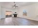Bright living room with wood floors, fireplace, ceiling fan, and natural light from large window at 3517 S Dapple Gray Rd, Las Vegas, NV 89147