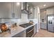 Close-up of modern kitchen features including a gas cooktop, quartz countertops, and sleek gray cabinetry at 494 Copper Falcon Ave, Henderson, NV 89011