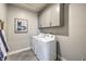This well-lit laundry room includes storage cabinets and a side-by-side washer and dryer at 494 Copper Falcon Ave, Henderson, NV 89011