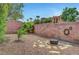 Landscaped backyard with decorative brick wall and stone firepit area at 519 Via Garofano Ave, Henderson, NV 89011