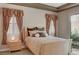 Bedroom with a bed, two windows with curtains and a nightstand at 519 Via Garofano Ave, Henderson, NV 89011