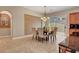 Dining area featuring a chandelier, slider to the backyard, and neutral color palette at 519 Via Garofano Ave, Henderson, NV 89011
